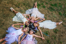 Group Of Young Girls Dressed As Fairies, Lying In Circle, Heads Together