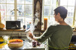 © Connect Images - Rear view of woman pouring beetroot into preserves jars in kitchen