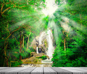 Canvas Print - Wooden tabletop with waterfall in forest background