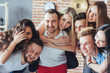 © standret - Group portrait of multi-ethnic boys and girls with colorful fashionable clothes holding friend  posing on a brick wall, Urban style people having fun, Concepts about youth  togetherness lifestyle