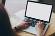 © Farknot Architect - Mockup image of hands using laptop with blank white screen on vintage wooden table in cafe