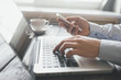 © lumenphotos - Hands using laptop and phone for online shopping, Daytime soft light