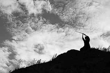 Wall Mural - Silhouette black and white photo warrior with sword on the mountain