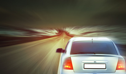 Wall Mural - car speeding on a highway at the sunset