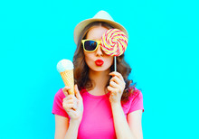 Fashion Portrait Young Woman Making An Air Kiss With Lollipop And Ice Cream Over Colorful Blue Background