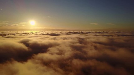 Wall Mural - Beautiful sunset view from above the clouds with clouds passing by the horizon. Magical nature.