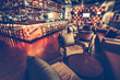 © Goinyk - A modern restaurant cafe interior with chair, table, sofa, lighting and bar decoration wall with alcohol ssortment. Concept of relaxing outside and communication. Vintage toning, dark lights
