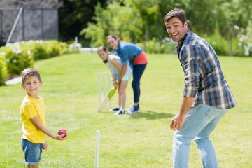 Happy family playing cricket together