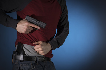 Man drawing a concealed carry pistol from a holster