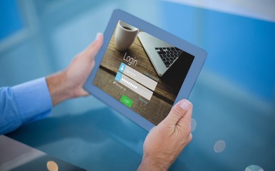 Composite image of businessman using his tablet 