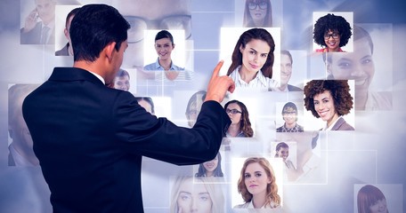 Poster - Composite image of thoughtful asian businessman pointing