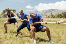 People Playing Tug Of War During Obstacle Training Course