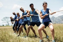 People Playing Tug Of War During Obstacle Training Course