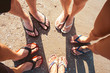 Five pare of legs on the sand of the beach