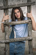 Portrait of pretty young woman holding rustic wooden ladder