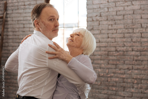Fotografía Involved aged dance couple waltzing in the dance studio
