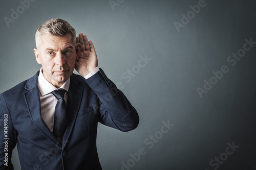 businessman trying to hear something