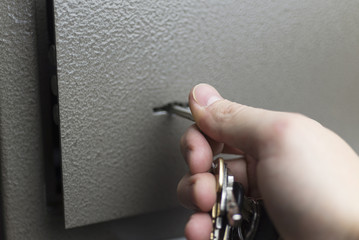 The hand with the keys opens the safe Deposit box.