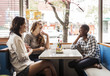 © Cavan Images - Smiling woman sitting in cafe during lunch