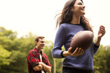 Couple Playing American Football In Backyard