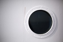 White Boat With Round Dark Porthole Window With Hanging Chain Hook