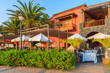 Poster - Typical restaurant built in colonial style during sunset time in Costa Adeje holiday town on Tenerife island, Spain