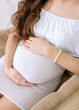© melnikofd - Hands of the pregnant woman on a tummy. Pregnant woman in a white dress. Mother's hands. Waiting for a baby. Pregancy concept.