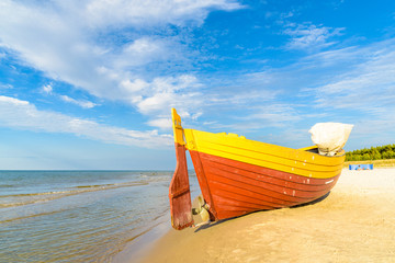 Wall Mural - Colorful fishing boat on sandy Debki beach during sunny summer day, Baltic Sea, Poland