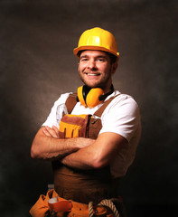 Builder in yellow helmet, protective glasses and working clothes