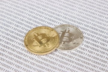 Wall Mural - gold and silver bitcoin on the background of binary code