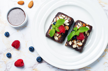 Raw vegan no bake chocolate dates almond brownies with chocolate frosting and berries