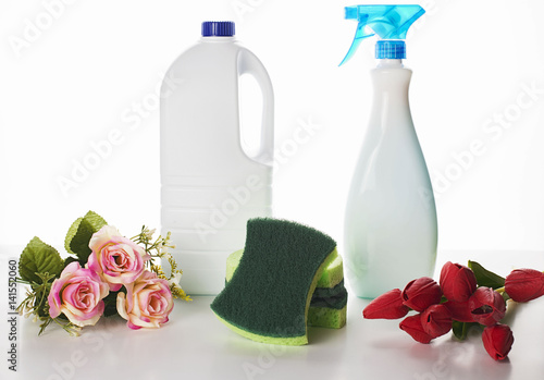 Fotografie, Obraz Small bunch of red and pink flowers placed near the cleaning chemistry bottles a