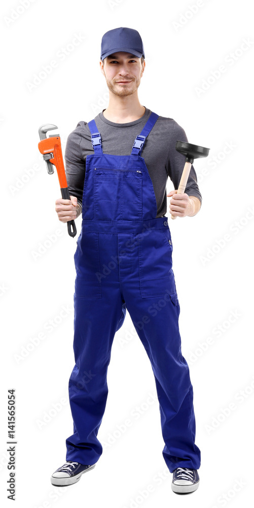 Young plumber holding pipe wrench and plunger on white background
