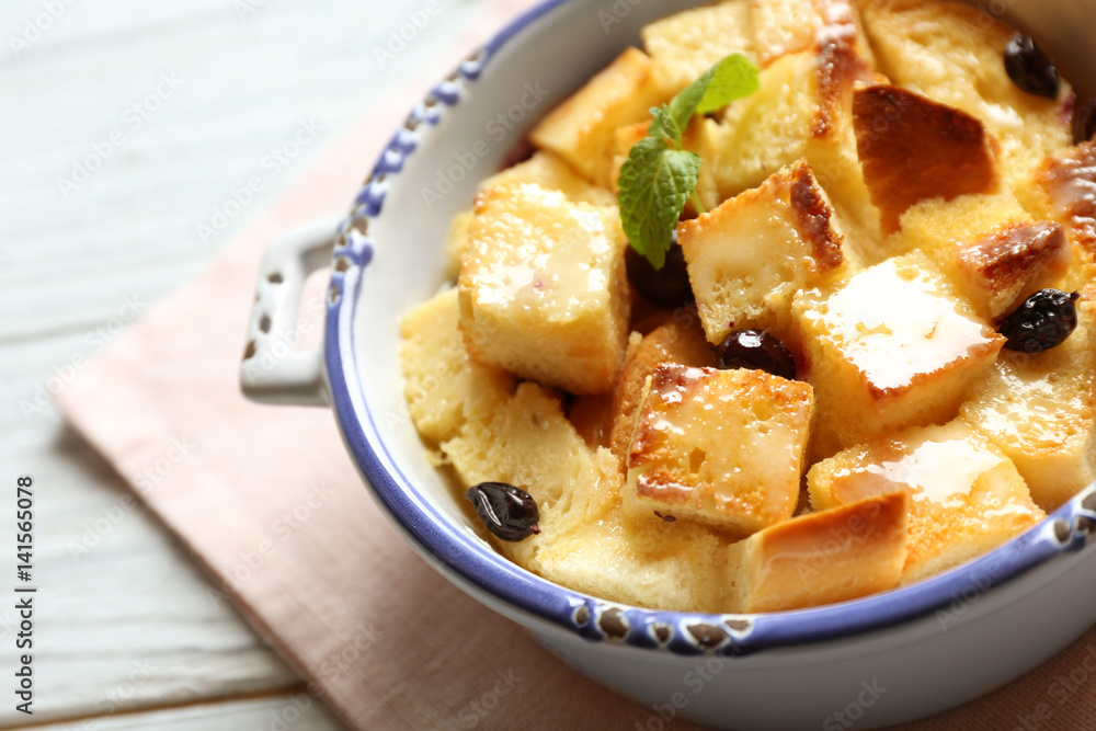 Bowl with delicious bread pudding on napkin
