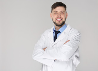 Sticker - Young handsome pharmacist with crossed arms on grey background