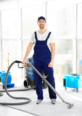 Wall Mural - Dry cleaner's employee removing dirt from carpet in flat