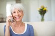 © WavebreakMediaMicro - Smiling senior woman talking on mobile phone in living room