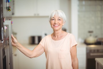 Wall Mural - Portrait of senior woman standing in kitchen