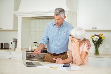 Wall Mural - Senior man interacting with senior woman in kitchen 