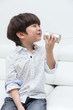 Leinwandbild Motiv Asian Chinese little boy playing retro tin can phone