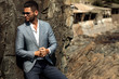 © ASjack - Man in elegant suite posing in rock background