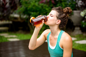 Young woman refreshing with drinking water