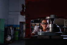 Female Mechanic Operating Hydraulic Press