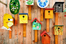 Artsy Birdhouses Exhibited On A Wooden Wall Outdoors