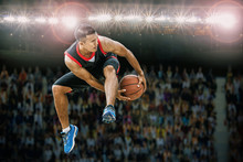 Basketball Player Jumping And Dribbling Ball In The Air,Action In The Stadium During Match