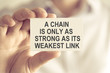Businessman holding A CHAIN IS ONLY AS STRONG AS ITS WEAKEST LINK message card