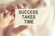 © stanciuc - Businessman holding SUCCESS TAKES TIME message card