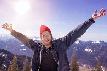 Wall Mural - young bearded man surrounded by mountains stretching his arms