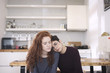 © Cavan Images - Lesbian couple relaxing while sitting by table at home