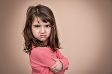 Angry And Pouting Cute Young Girl With Crossed Arms